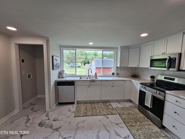 335 Bristol Rd, Harrogate, TN 37752 - kitchen featuring appliances with stainless steel finishes, a sink, white cabinetry, light marble finish floors, and baseboards