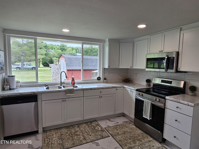 335 Bristol Rd, Harrogate, TN 37752 - kitchen with stainless steel appliances, light marble finish floors, a sink, white cabinets, and recessed lighting