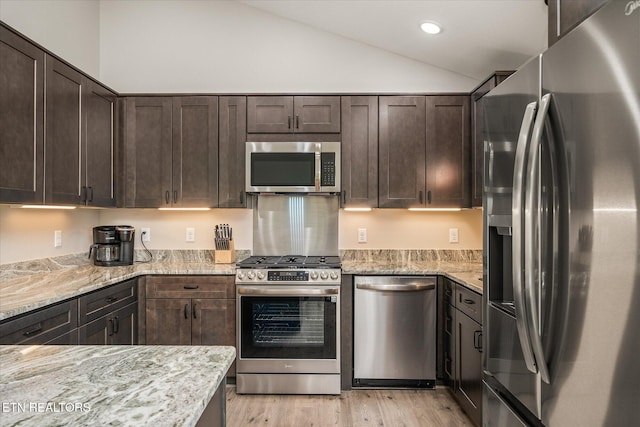 27 Jesse Loop, Crossville, TN 38555 - kitchen featuring stainless steel appliances, lofted ceiling, dark brown cabinets, light wood-style floors, and light stone countertops