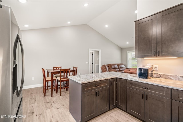 27 Jesse Loop, Crossville, TN 38555 - kitchen featuring stainless steel refrigerator with ice dispenser, dark brown cabinets, a peninsula, light wood-type flooring, and vaulted ceiling