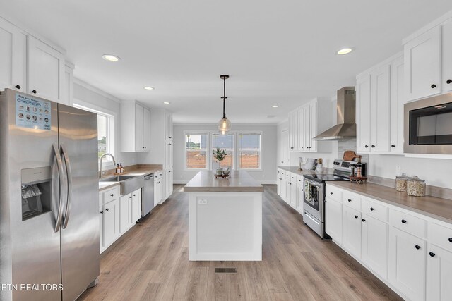 1559 River Path, Morristown, TN 37813 - kitchen featuring appliances with stainless steel finishes, wall chimney exhaust hood, a sink, a kitchen island, and white cabinetry