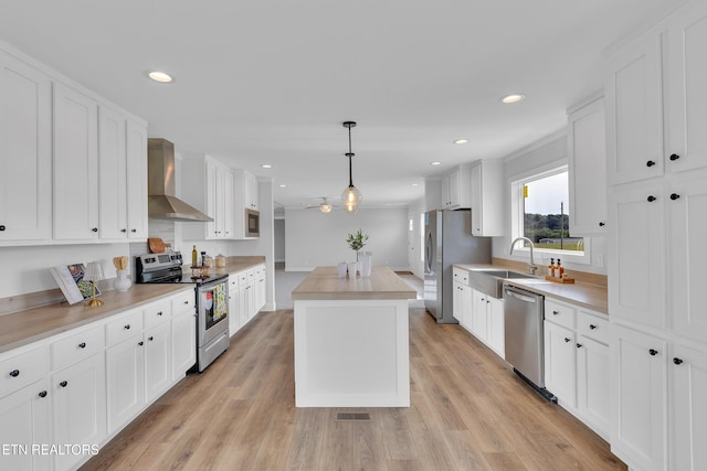 1559 River Path, Morristown, TN 37813 - kitchen with appliances with stainless steel finishes, wall chimney range hood, a sink, a kitchen island, and white cabinets