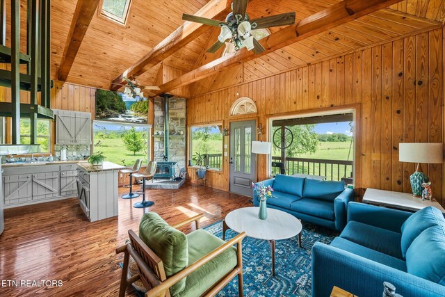 2892 N York Hwy, Pall Mall, TN 38577 - living area with beamed ceiling, wood walls, a wood stove, wooden ceiling, and plenty of natural light