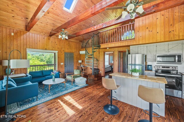 2892 N York Hwy, Pall Mall, TN 38577 - living area with ceiling fan, wooden walls, stairway, dark wood-type flooring, and a skylight
