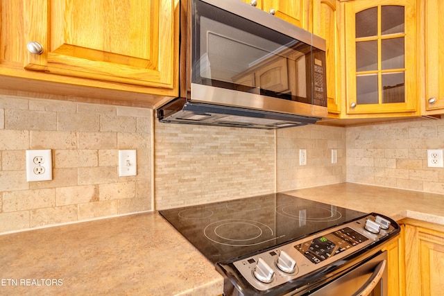4913 Ivy Rose Dr, Knoxville, TN 37918 - kitchen featuring stainless steel appliances, glass insert cabinets, decorative backsplash, and light countertops