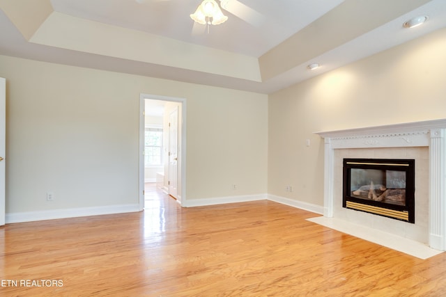 4913 Ivy Rose Dr, Knoxville, TN 37918 - unfurnished living room featuring a raised ceiling, a tile fireplace, light wood-style flooring, baseboards, and recessed lighting