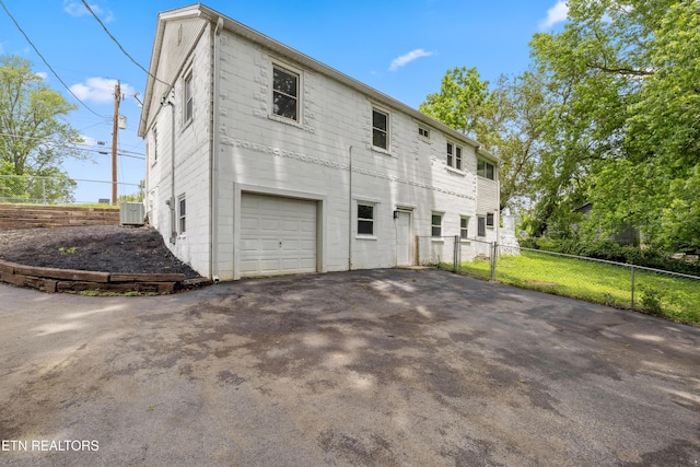 308 Nash Rd, Knoxville, TN 37914 - back of property with an attached garage, central air condition unit, asphalt driveway, and fence