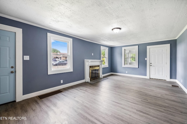 308 Nash Rd, Knoxville, TN 37914 - unfurnished living room with a textured ceiling, crown molding, wood finished floors, a glass covered fireplace, and baseboards