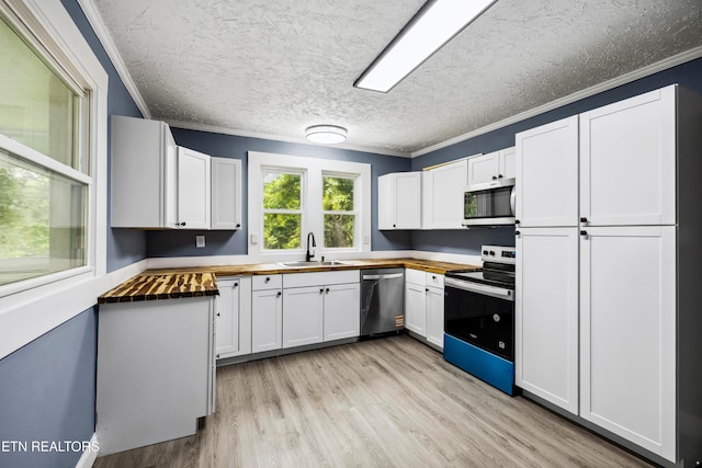 308 Nash Rd, Knoxville, TN 37914 - kitchen with appliances with stainless steel finishes, wooden counters, a sink, crown molding, and light wood finished floors