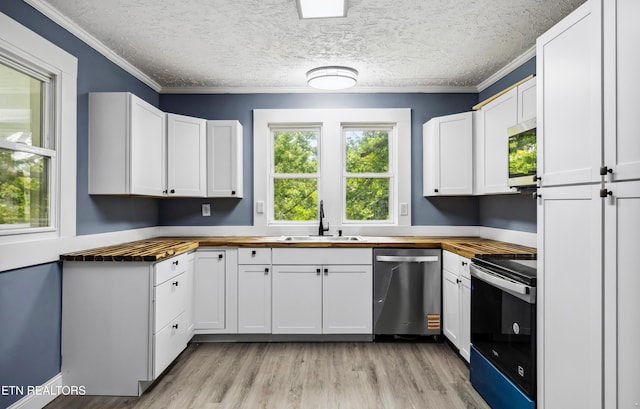 308 Nash Rd, Knoxville, TN 37914 - kitchen featuring wood counters, appliances with stainless steel finishes, a sink, ornamental molding, and white cabinets