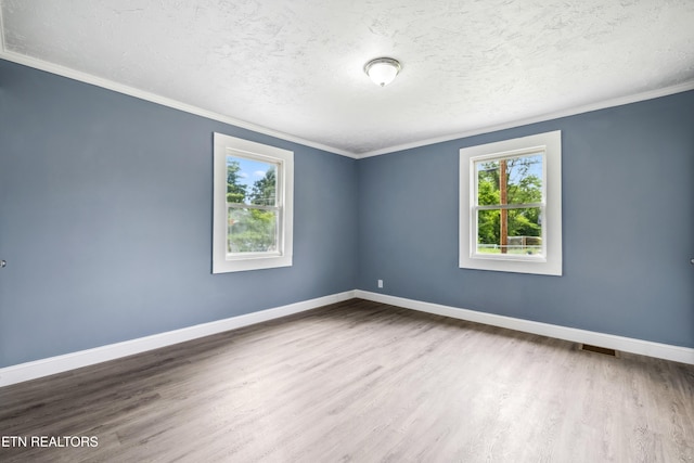 308 Nash Rd, Knoxville, TN 37914 - unfurnished room featuring plenty of natural light, wood finished floors, baseboards, a textured ceiling, and ornamental molding