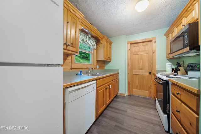 kitchen with white appliances, a sink, dark wood-style flooring, light countertops, and a textured ceiling