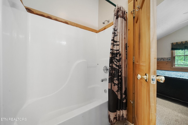 bathroom with lofted ceiling and shower / bath combo