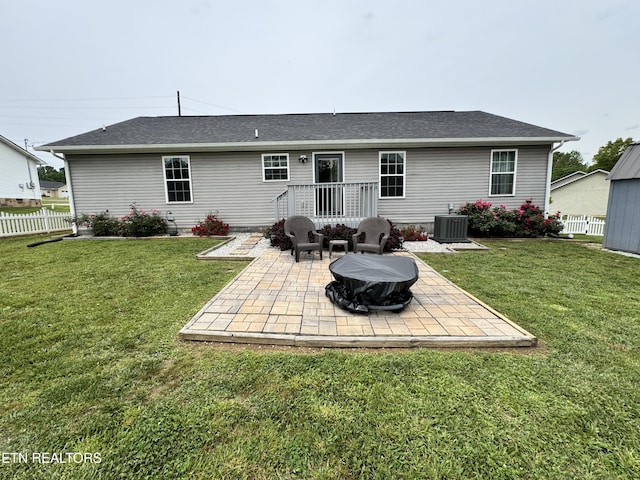 rear view of house featuring a patio area, an outdoor fire pit, central AC unit, and roof with shingles