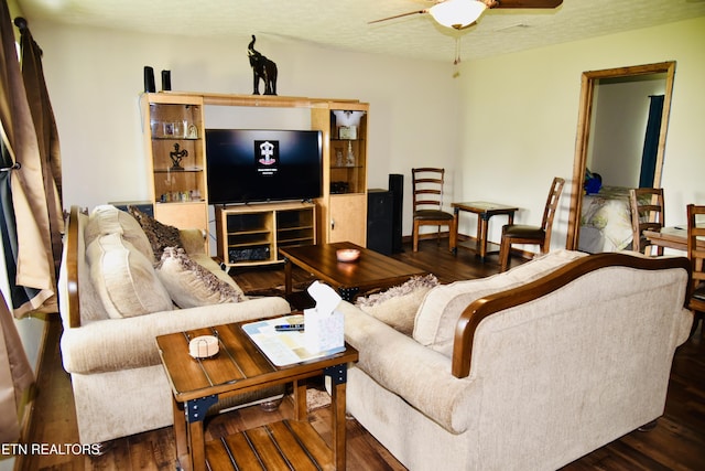 living room with ceiling fan, wood finished floors, and a textured ceiling