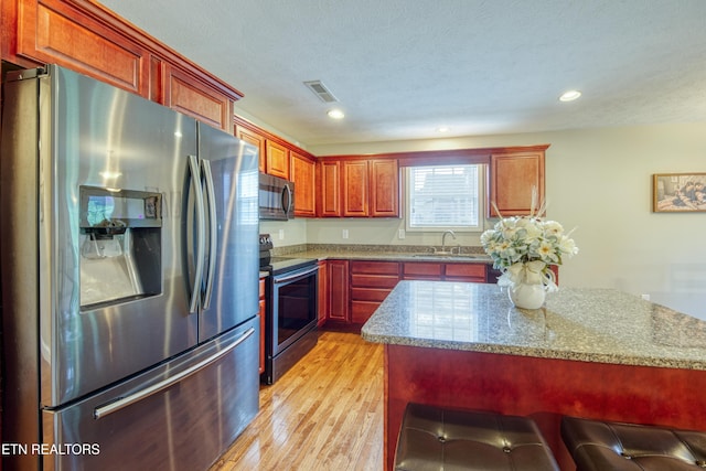 4432 Old Colony Ln, Morristown, TN 37814 - kitchen featuring appliances with stainless steel finishes, light wood-style flooring, a sink, light stone countertops, and recessed lighting