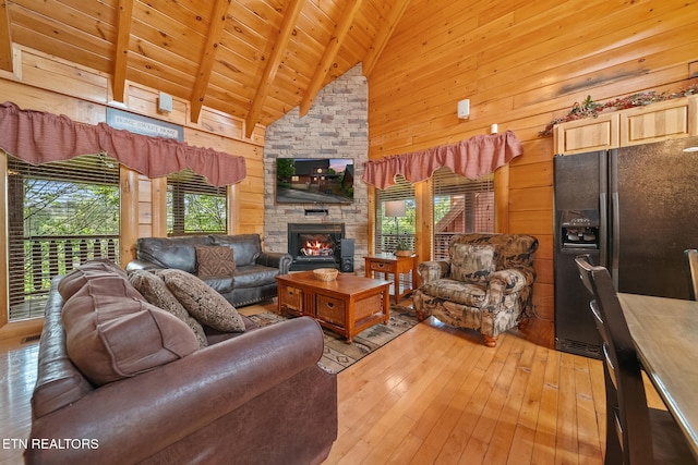 2006 Cougar Crossing Way, Sevierville, TN 37862 - living room with beam ceiling, wooden ceiling, light wood-type flooring, wooden walls, and a stone fireplace