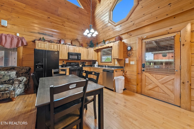 2006 Cougar Crossing Way, Sevierville, TN 37862 - kitchen with black appliances, wood walls, a towering ceiling, dark countertops, and light wood-style floors