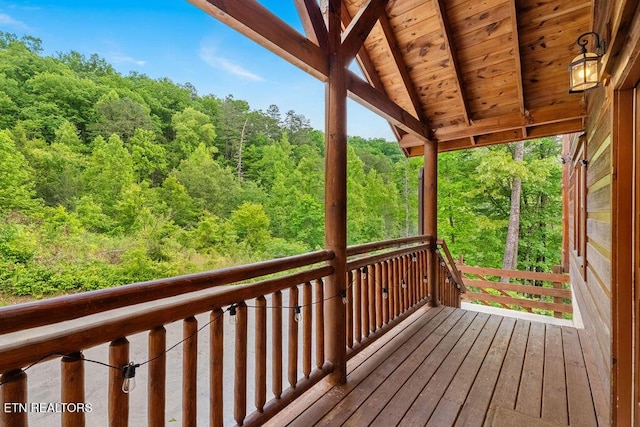 wooden terrace featuring a wooded view