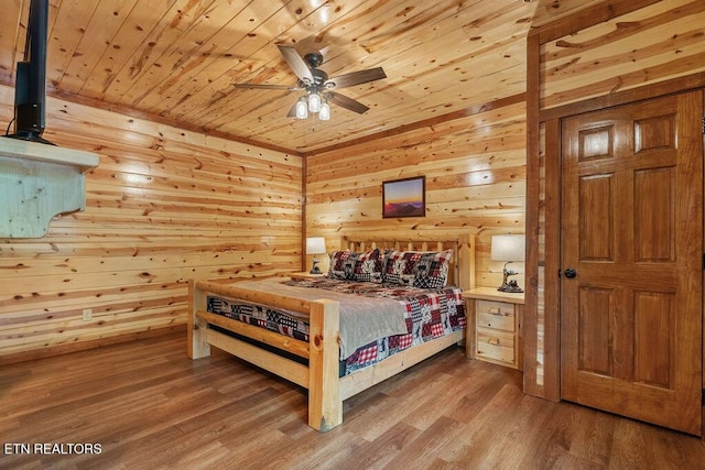 bedroom featuring wood ceiling, wood finished floors, and wood walls