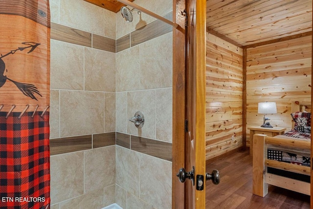 full bathroom with a tile shower, wood finished floors, wooden ceiling, and wooden walls