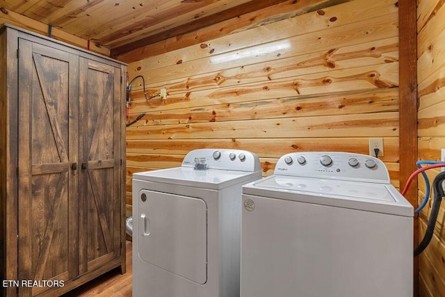 laundry area featuring wood walls, washing machine and dryer, wooden ceiling, and light wood-style flooring