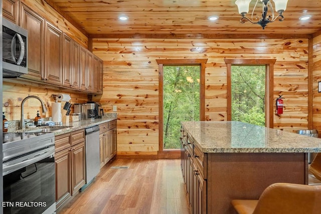 kitchen with stainless steel appliances, a sink, wood ceiling, light wood-style flooring, and a chandelier
