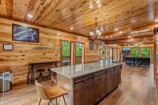 kitchen featuring wooden ceiling, light wood-style flooring, healthy amount of natural light, open floor plan, and wood walls