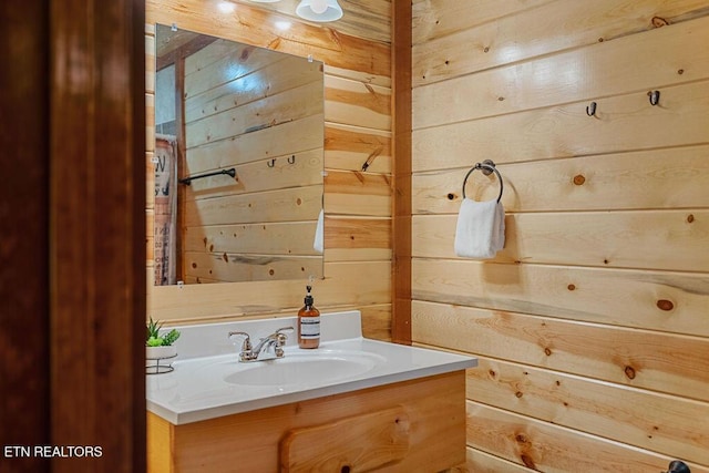 bathroom featuring wood walls and vanity