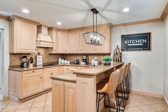kitchen featuring light tile patterned flooring, premium range hood, a kitchen bar, a peninsula, and a chandelier