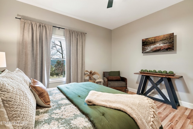 bedroom with wood finished floors, baseboards, and ceiling fan