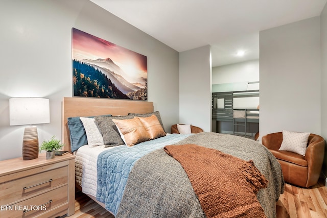 bedroom with wood finished floors and recessed lighting