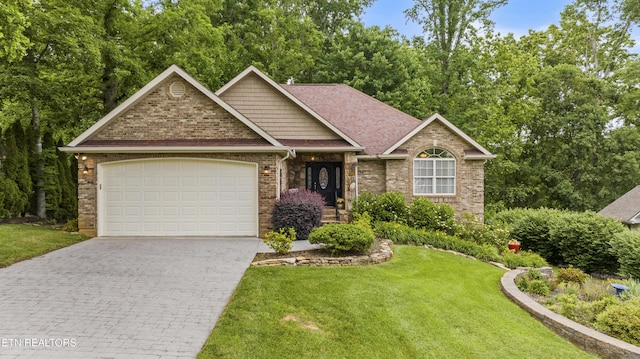 view of front of property with an attached garage, decorative driveway, a front lawn, and brick siding