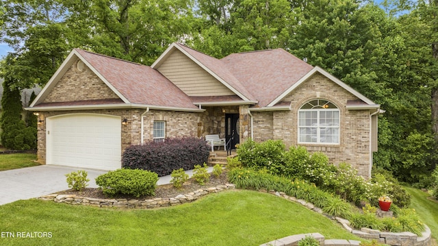 view of front of property featuring driveway, an attached garage, a front yard, and roof with shingles
