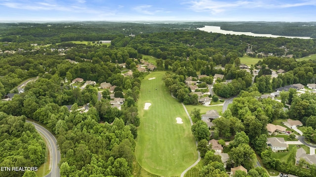 aerial view of residential area featuring a nearby body of water, a golf club, and a forest