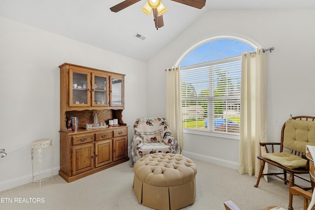 living area featuring vaulted ceiling, a ceiling fan, light colored carpet, and baseboards
