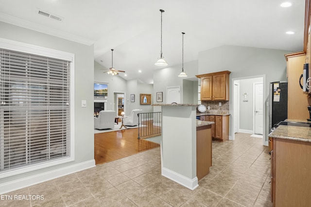 kitchen featuring lofted ceiling, a ceiling fan, light tile patterned flooring, tasteful backsplash, and light stone countertops