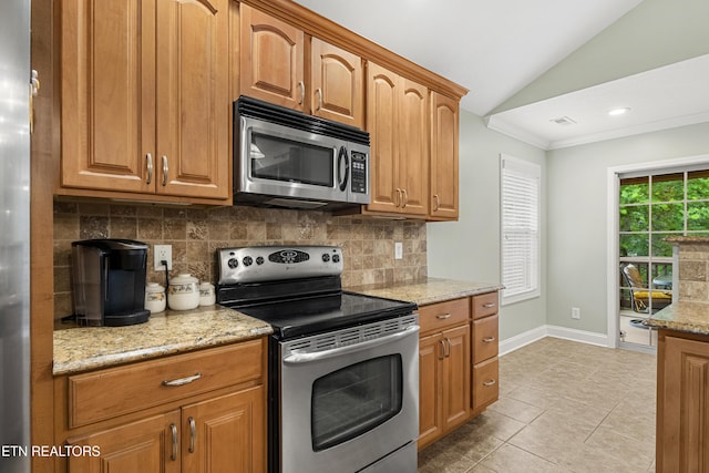 kitchen featuring stainless steel appliances, lofted ceiling, tasteful backsplash, baseboards, and light stone countertops