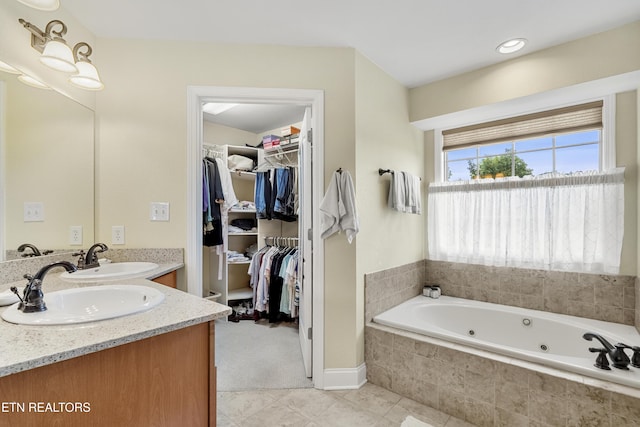 bathroom featuring a jetted tub, double vanity, tile patterned flooring, and a walk in closet