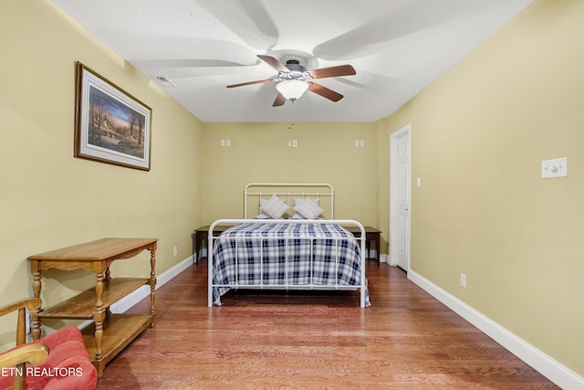 bedroom featuring wood finished floors and baseboards