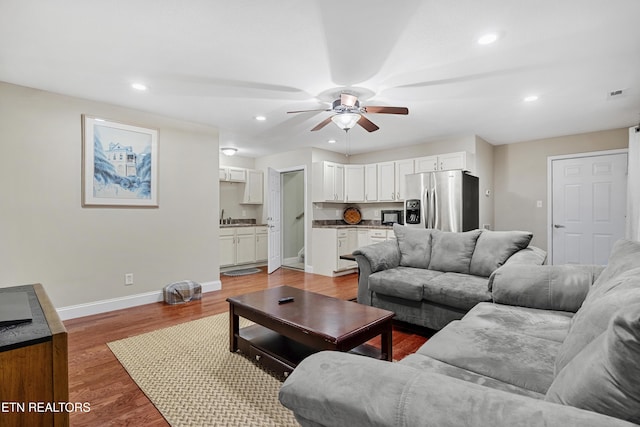 living area with a ceiling fan, baseboards, recessed lighting, and light wood-style flooring