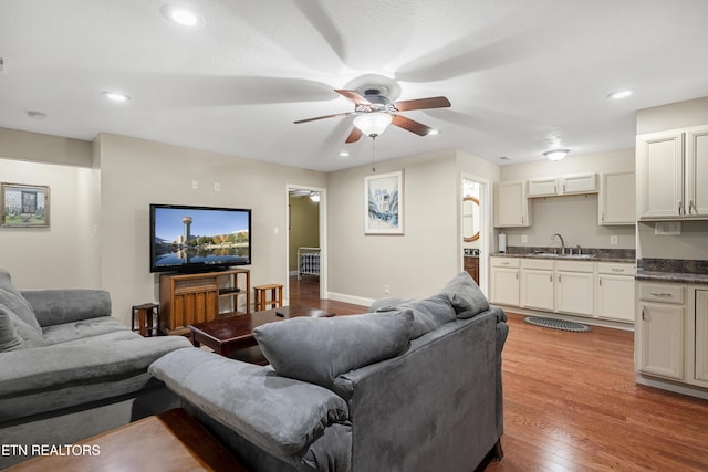 living room featuring a ceiling fan, light wood-style flooring, recessed lighting, and baseboards