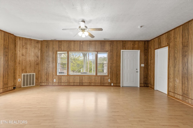 313 W Spring St, Oliver Springs, TN 37840 - unfurnished room with light wood-type flooring, a ceiling fan, wood walls, baseboards, and a textured ceiling