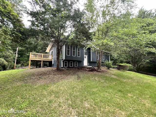 back of house featuring a deck and a lawn