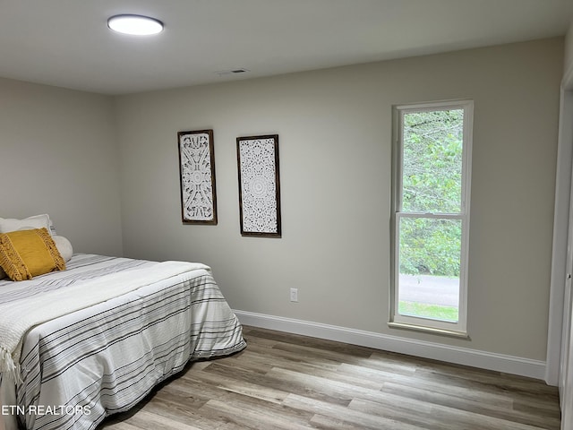 bedroom featuring wood finished floors and baseboards