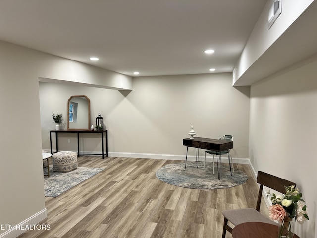 finished basement featuring wood finished floors, recessed lighting, and baseboards