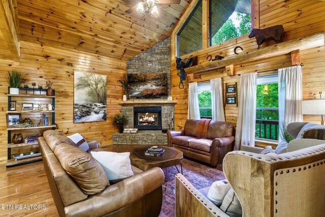 3330 Robeson Rd, Sevierville, TN 37862 - living room with wood finished floors, high vaulted ceiling, a stone fireplace, wooden walls, and wooden ceiling