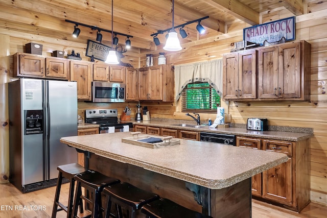 kitchen featuring stainless steel appliances, wood ceiling, track lighting, wood walls, and light wood finished floors