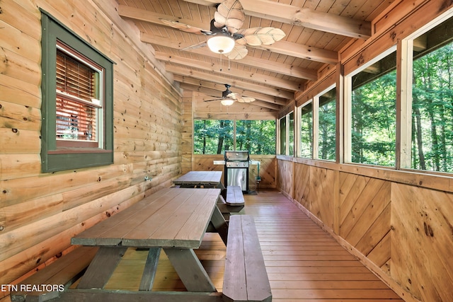 unfurnished sunroom featuring healthy amount of natural light and ceiling fan