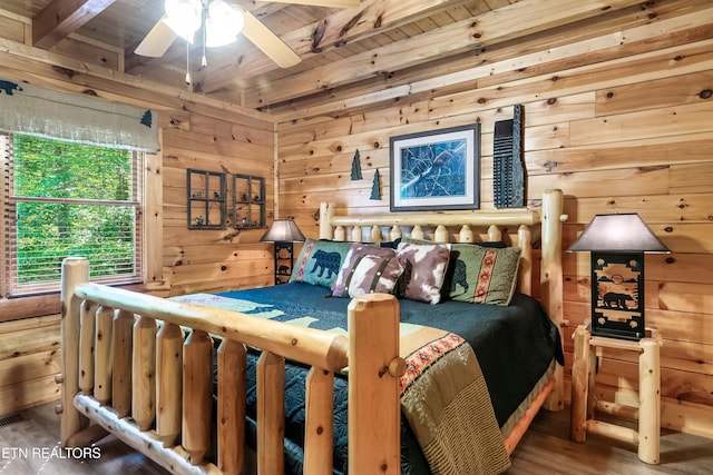 bedroom with wood walls, wooden ceiling, beam ceiling, and wood finished floors